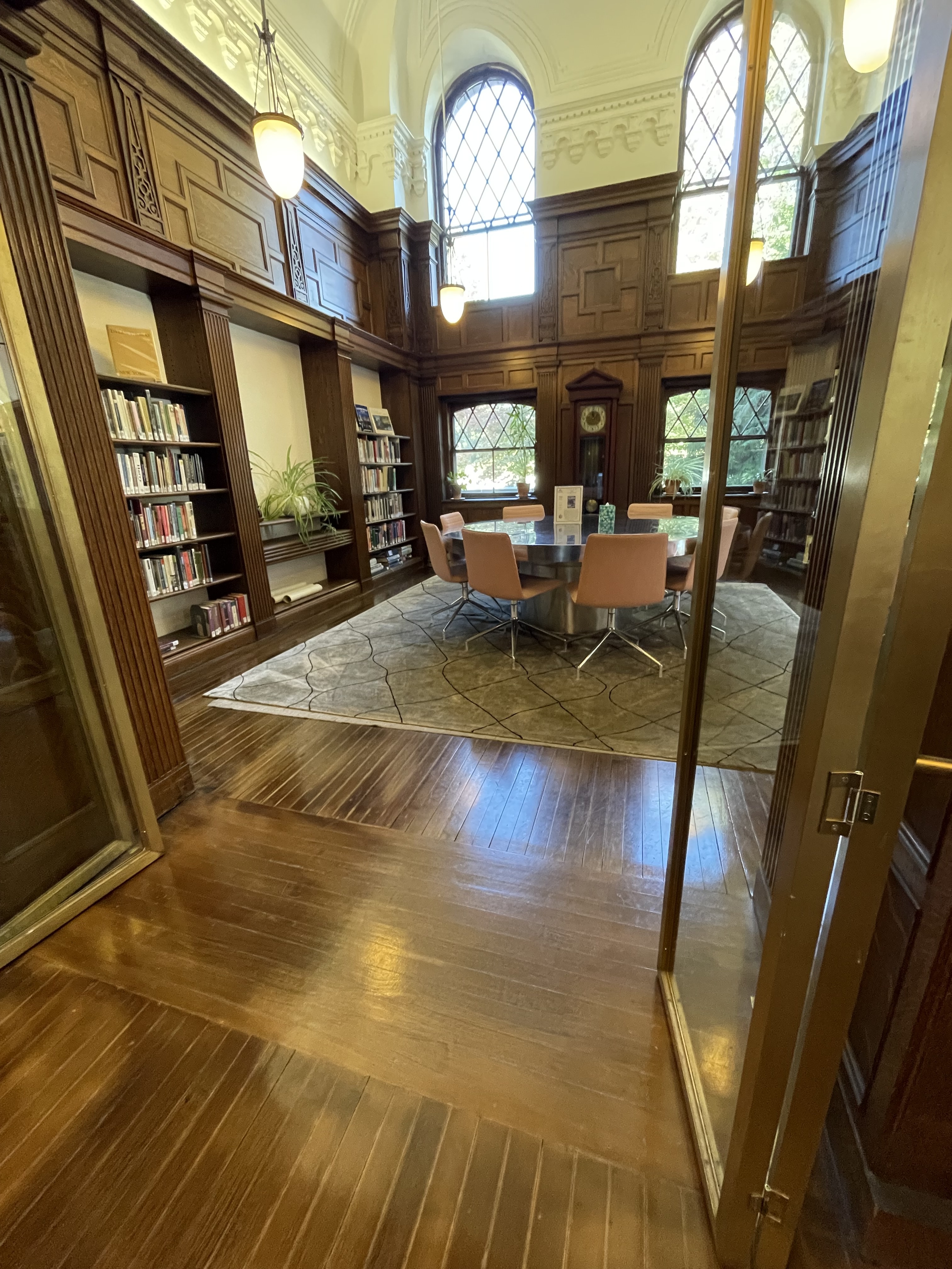 Meeting room with round table, wood shelves, and arched windows