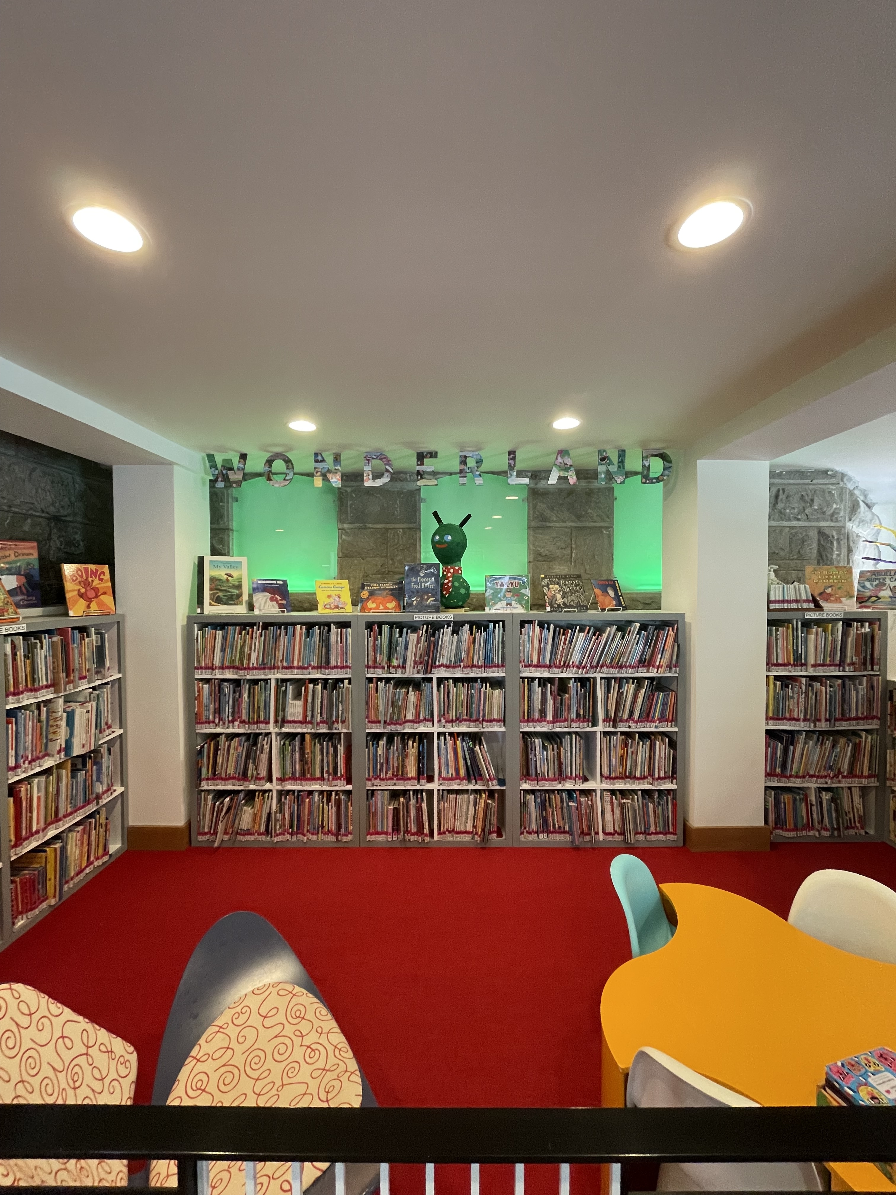 Wonderland ceiling sign and red carpet with organic shaped table and chairs