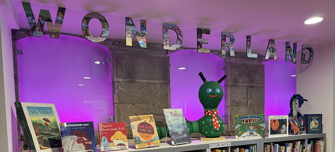 Children's area with a banner that reads "Wonderland" with a display of books on top of a shelf