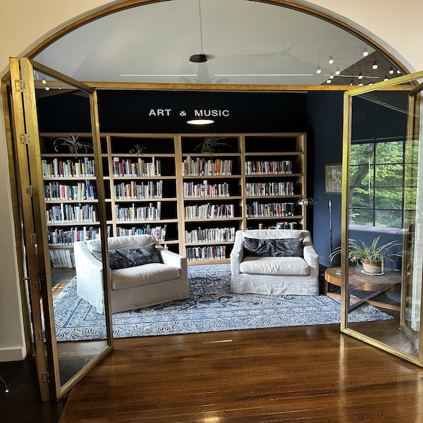 A cozy room with tw0 soft arm chairs and a small coffee table.