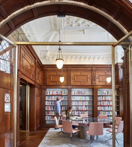 Small meeting room with bookcases and a large round table and chairs.