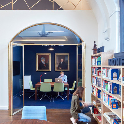 A small work/study room with a rectangular table and six chairs.